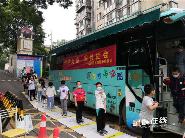 长沙图书馆流动图书车开进博才西湖小学,早已等候多时的孩子们排成一