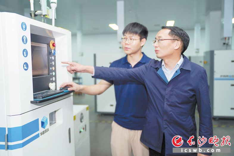 　　华翔医疗研发副总经理王国华（右）在生产车间与工作人员查看钽金属增材制造椎间融合器生产细节。均为长沙晚报全媒体记者 邓迪 摄