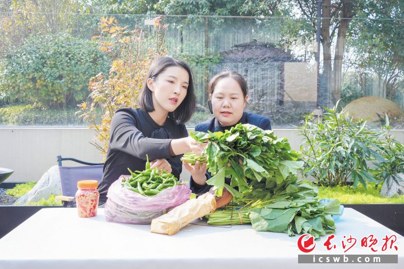 小院里,邓子怡(左)正在查看从当地农户收购来的各类农产品。 长沙晚报全媒体记者 何文瑞 摄