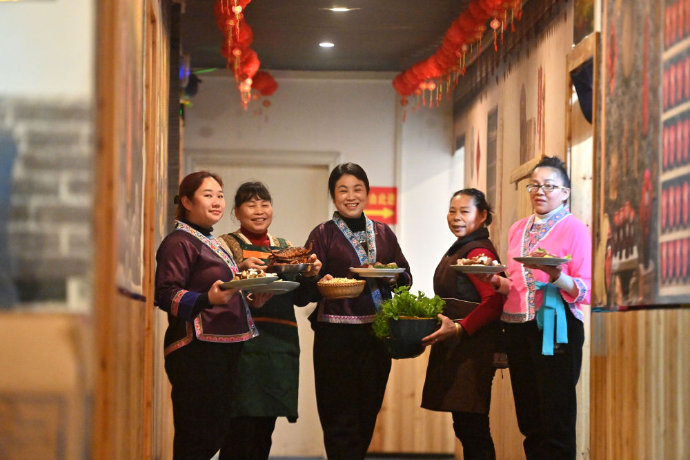 2025年2月28日，在广西柳州市融水苗族自治县融水镇一家餐馆，负责人吴葵花（中）和员工展示菜品。吴葵花经营餐馆22年，长期为当地农村群众提供稳定就业岗位，并收购偏远山区群众种植的蔬菜。在广西大山里，一批女能人活跃在农村电商、民宿餐饮、乡村文旅等各个领域，带动留守妇女发展产业，实现就近居家就业创业。新华社记者 黄孝邦 摄