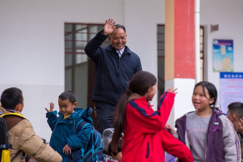 2025年2月18日，在落松地小学，农加贵（中）下课后和学生挥手告别。新华社记者 彭奕凯 摄