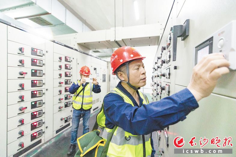 李伟强(前)和工友巡查营盘路隧道设备。