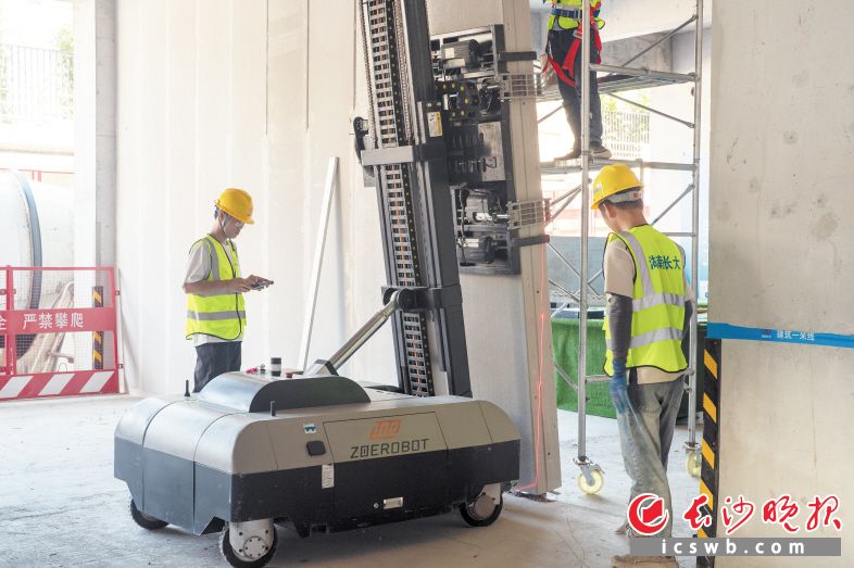 “90后”技术员张家康手持遥控器,像操作玩具汽车般精准操控着ALC墙板安装机器人。 长沙晚报全媒体记者 邓迪 摄