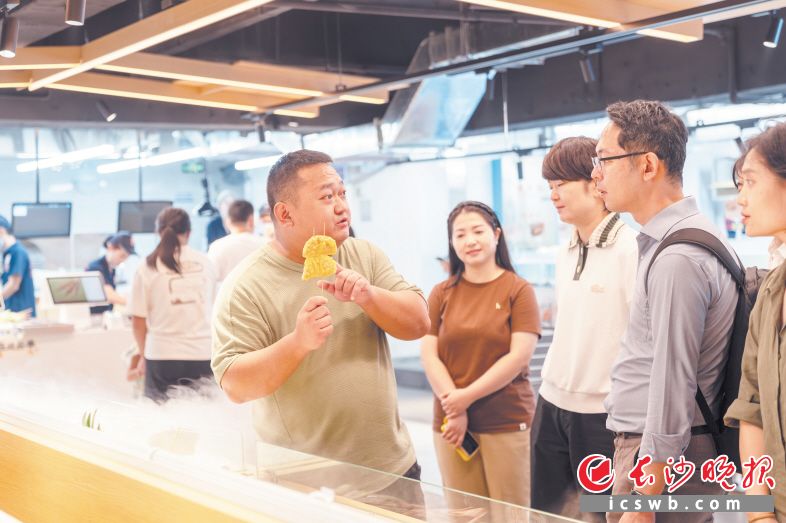 梁文欣（右五）在向前来考察的客商展示他腌制的烤串食材。长沙晚报全媒体记者 邓迪 摄