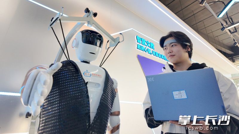 工作人员通过脑机接口控制机器人。