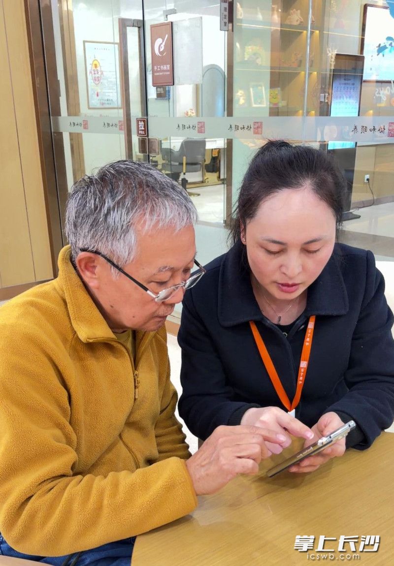 工作人员手把手指导老人家属（左）申领养老服务消费补贴。 均为长沙晚报全媒体记者刘俊摄