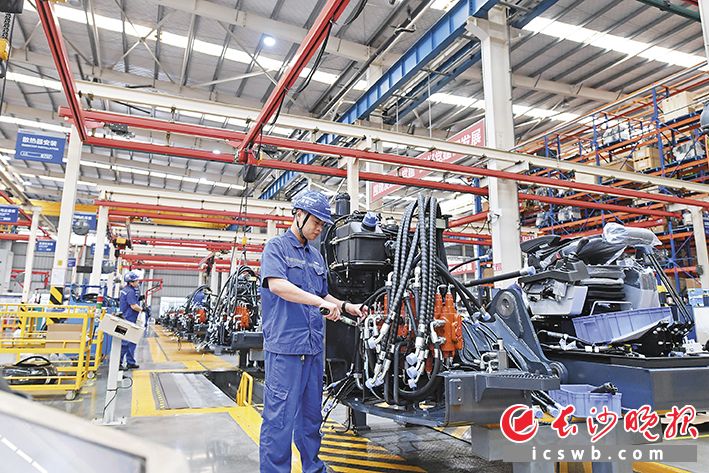 山河智能挖掘机总装车间内,机器轰鸣,各条装配生产线都在“全力开跑”,现场一派繁忙的生产景象。长沙晚报全媒体记者 王志伟 摄