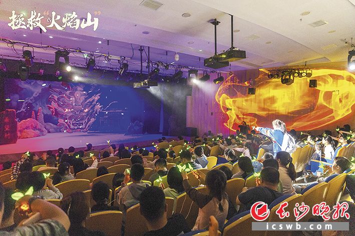 《拯救“火焰山”》剧场中，观影的孩子们举“枪”决定剧情走向。长沙晚报通讯员 张雨生 供图
