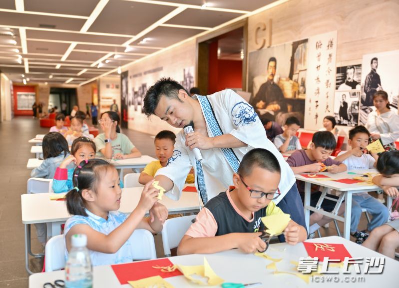 老师教孩子剪纸技巧。