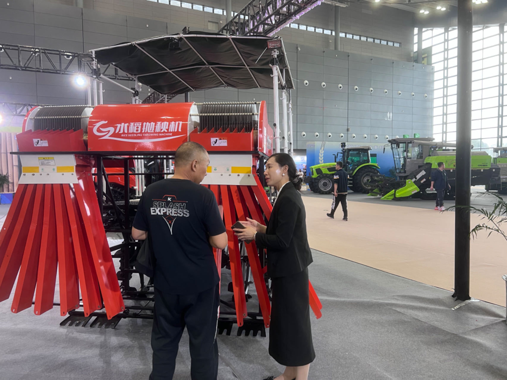 第二十四届中国中部农博会上，邓小玲正在和客户介绍公司研发生产的新型水稻抛秧机 孙超 摄